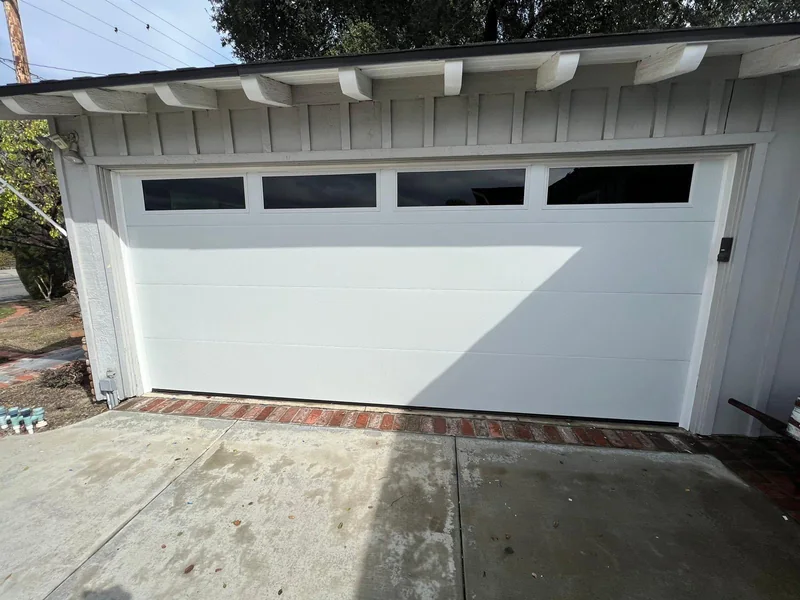 White garage door with a row of narrow rectangular windows.