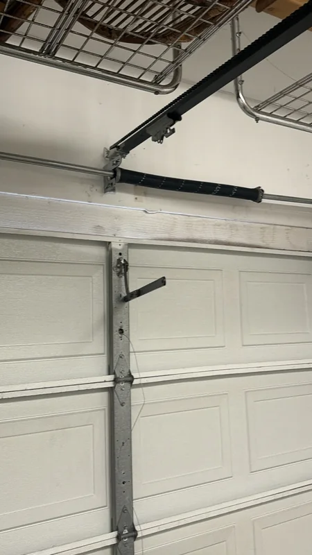 Interior garage door showing a torsion spring, center bracket and opener rail.