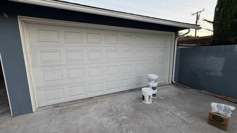 After the repair: the same white garage door closed.
