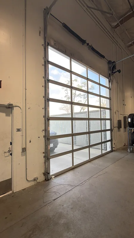Interior view of a glass-panel garage door with visible tracks and hinges.