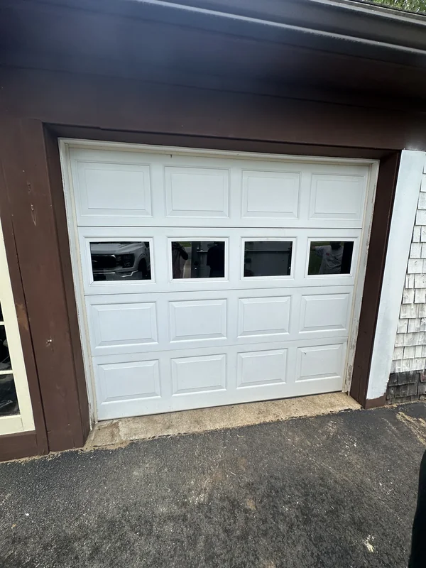 Single white garage door with a row of windows across the middle.
